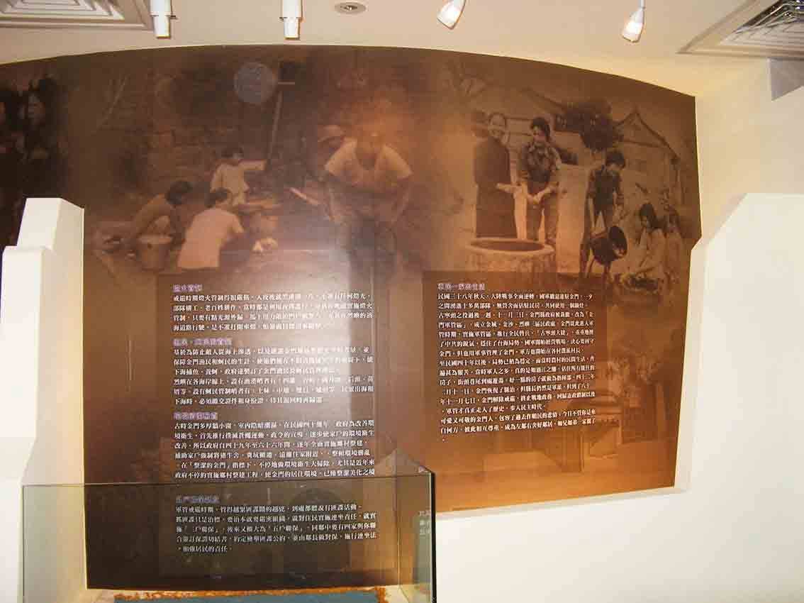 烈嶼鄉史館庶民生活展區弧形大圖牆，褐色調老照片呈現傳統打鐵、搗米與庶民勞動場景，下方搭配玻璃展示櫃