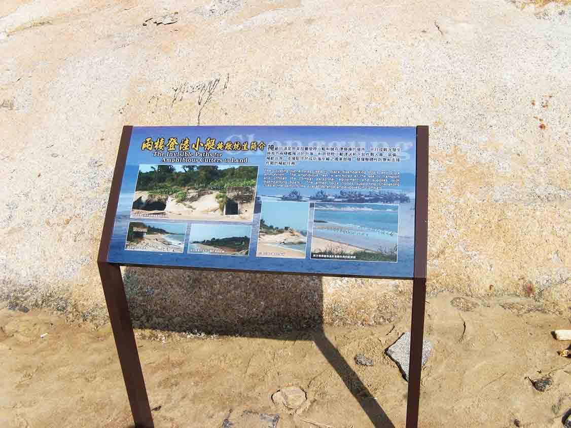 兩棲登陸小艇搶灘坑道簡介解說牌，藍色背板設立於岩岸沙地