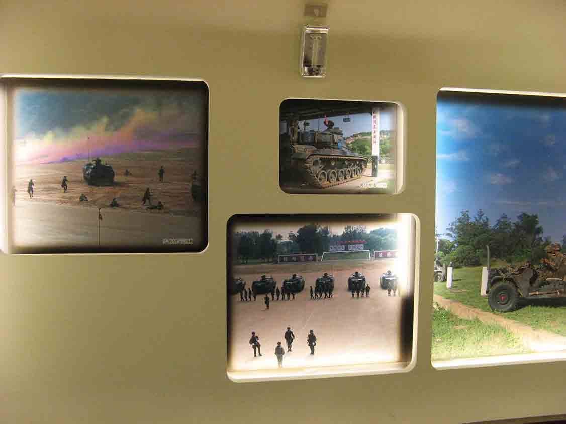 湖井頭戰史館圓角窗格牆面，展示登陸戰車衝灘、戰車整列、裝甲車叢林行軍等彩色軍事影像