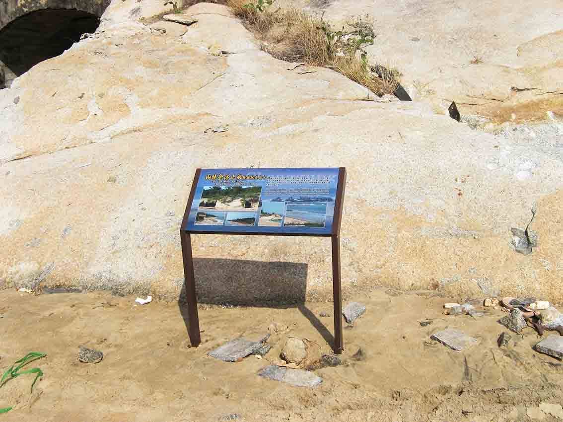 兩棲登陸小艇搶灘坑道解說牌現場全景，岩壁洞口為背景