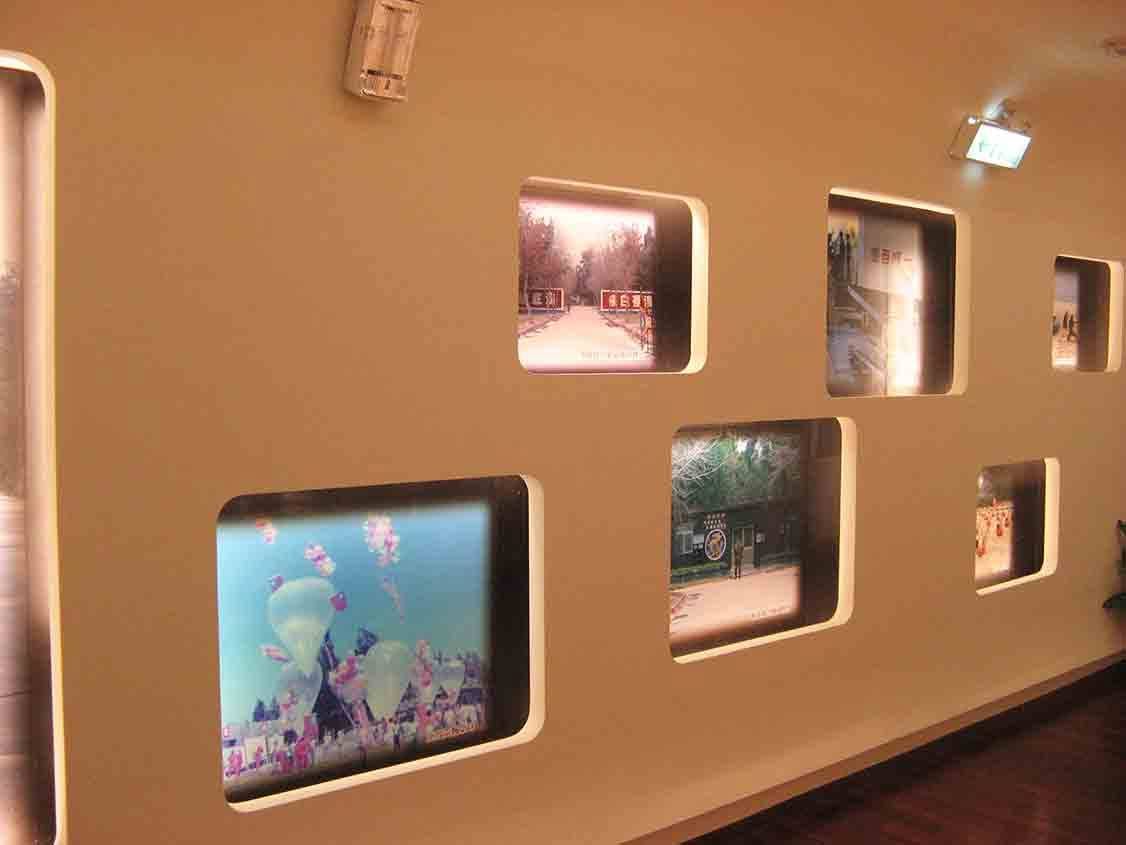 湖井頭戰史館圓角窗格展牆，展示營區大門、心戰空飄氣球與軍營門口衛兵等歷史影像