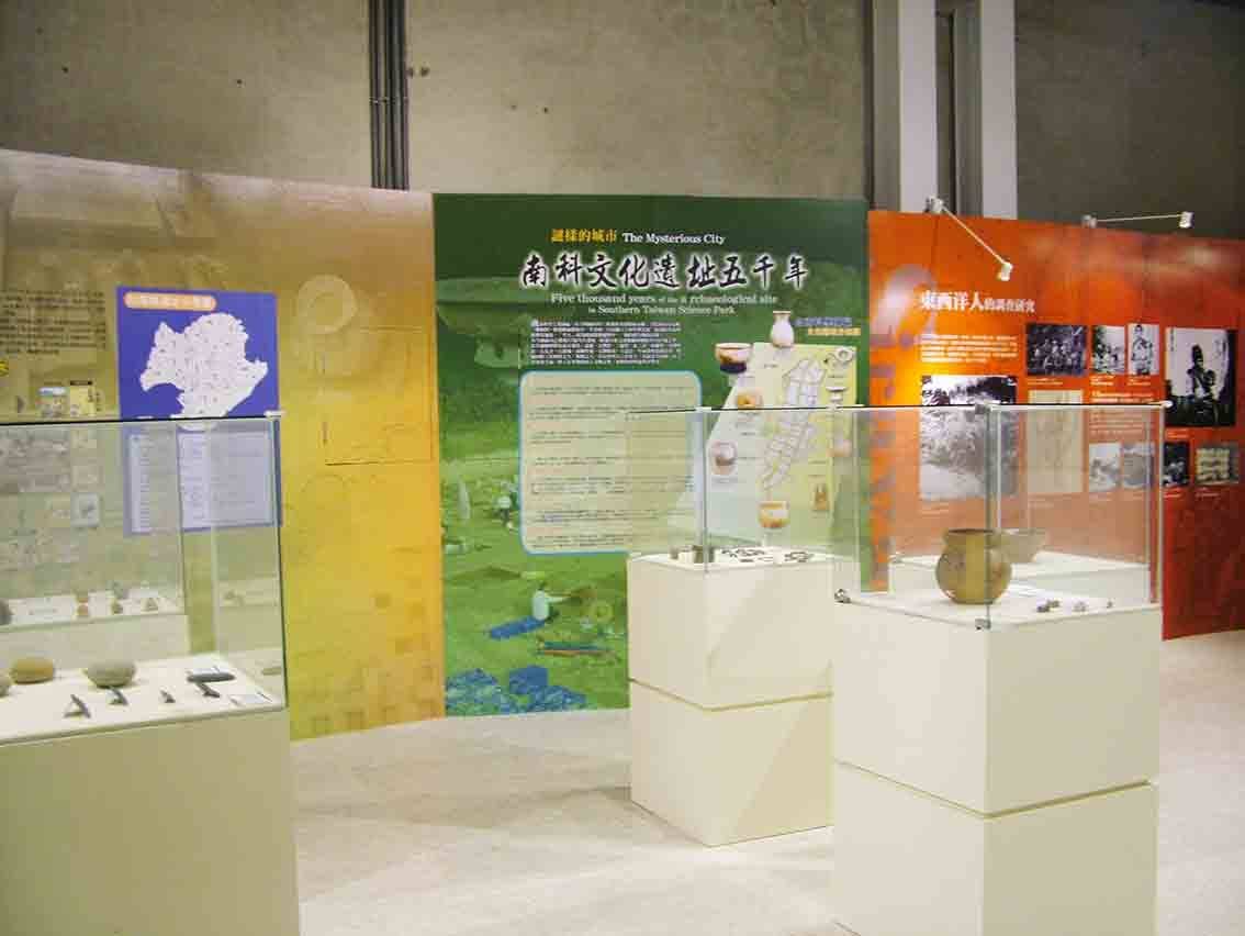 南科文化遺址五千年主題展牆，玻璃櫃內陶器與石器陳列