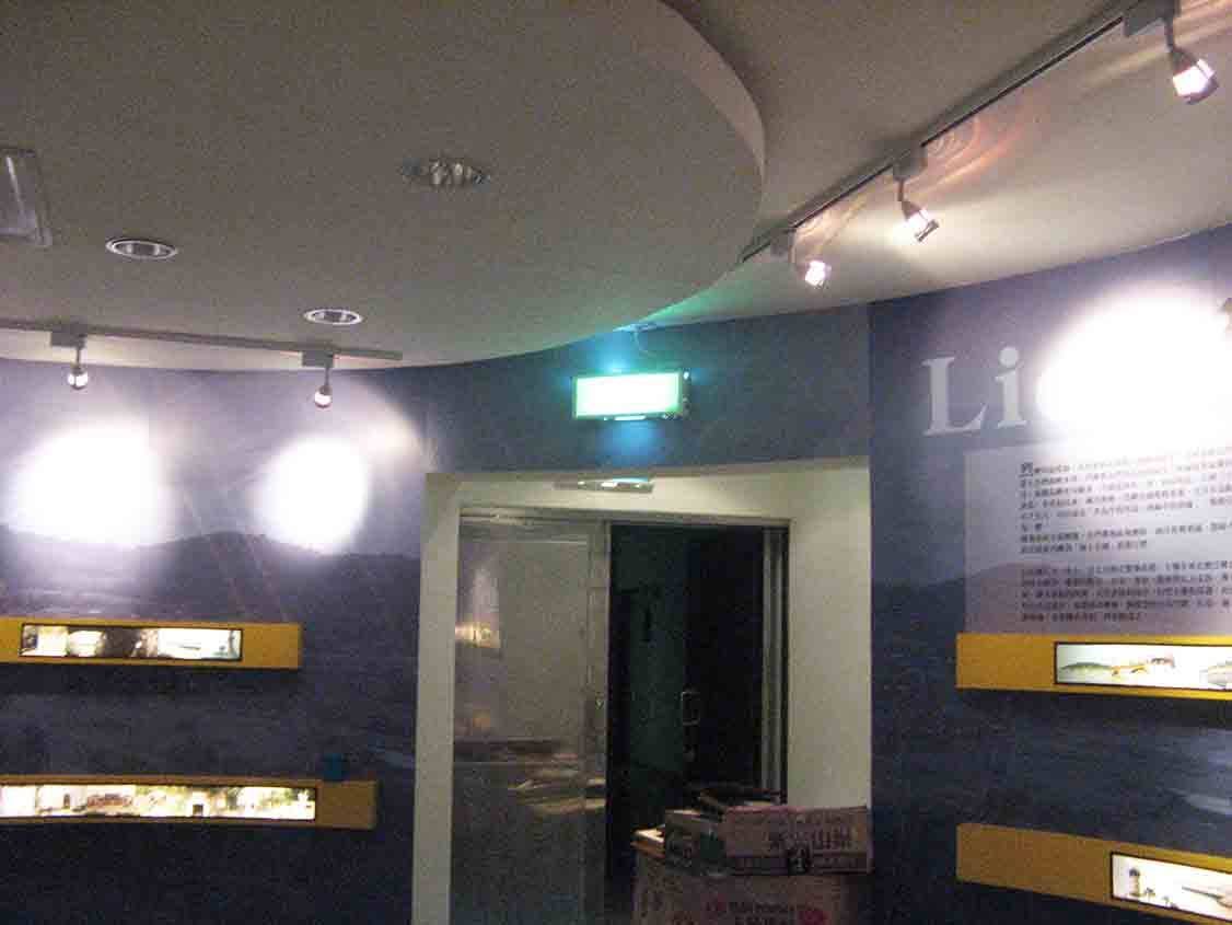 烈嶼鄉史館入口導引動線，深藍弧形展牆與黃色燈箱框出生態展示窗