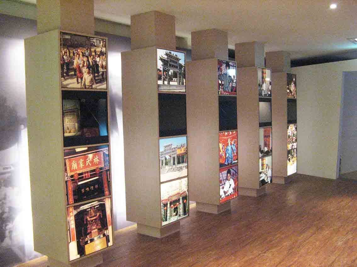 烈嶼鄉史館聚落文化柱狀燈箱展區全景，多支立柱燈箱展示宗祠、廟會與庶民影像