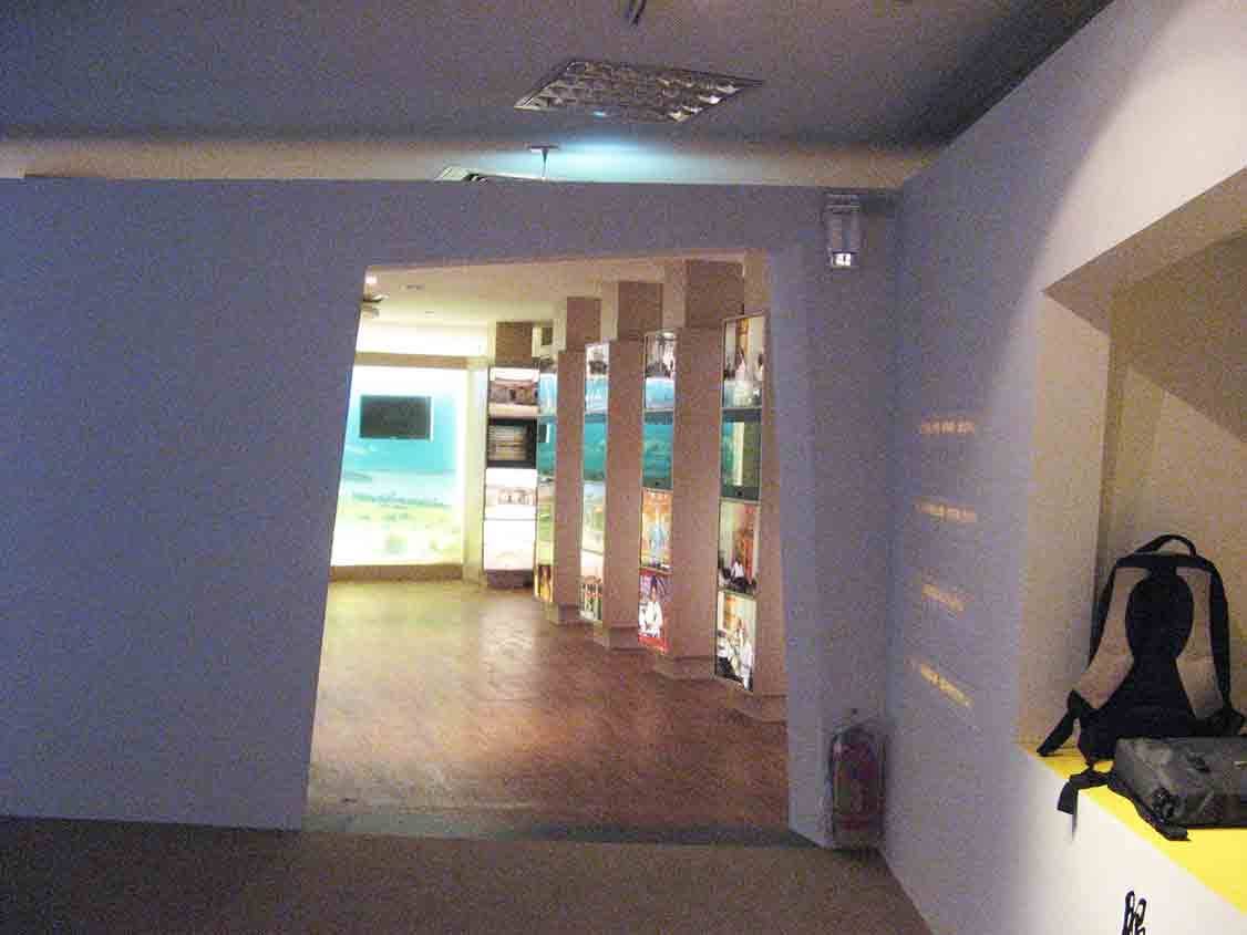 烈嶼鄉史館入口往柱狀燈箱展區望去的廊道，遠處可見影片播放區與發光展柱