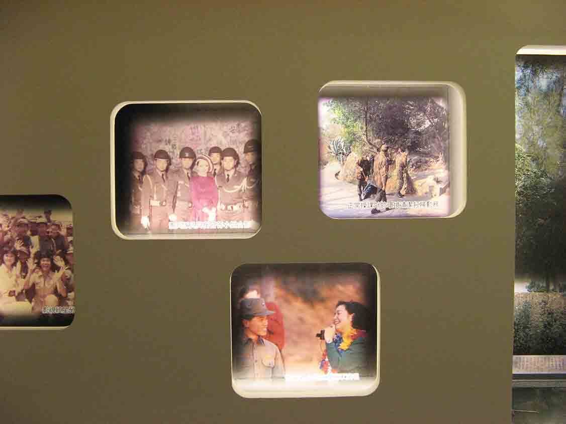 湖井頭戰史館橄欖綠牆面嵌牆圓角窗格展示，呈現國軍英雌、勞軍女星與部隊合影等彩色懷舊照片