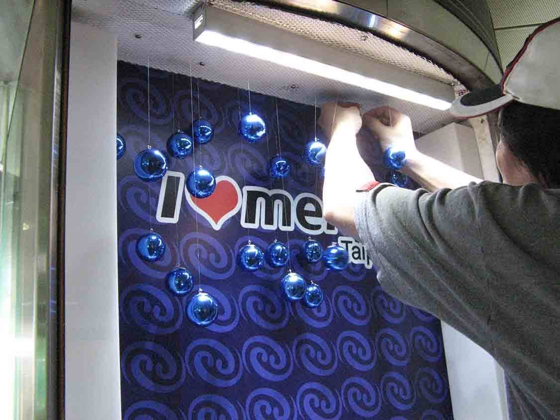 I Love Metro 燈箱背板安裝，藍色金屬球體吊飾施工特寫