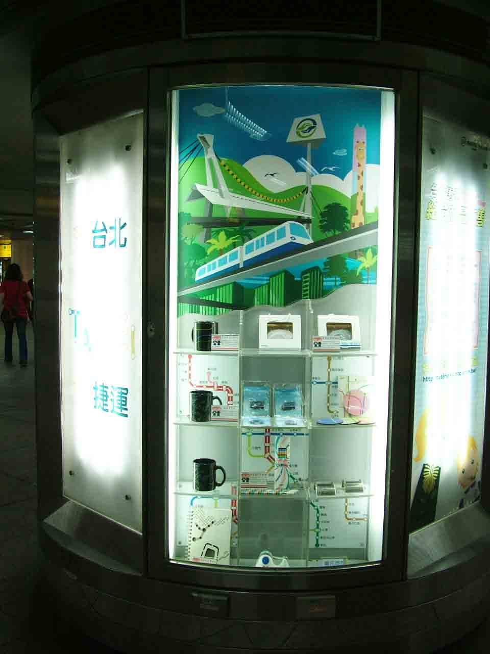 圓柱燈箱櫥窗整體視角，文湖線高架彩繪背板與路網商品