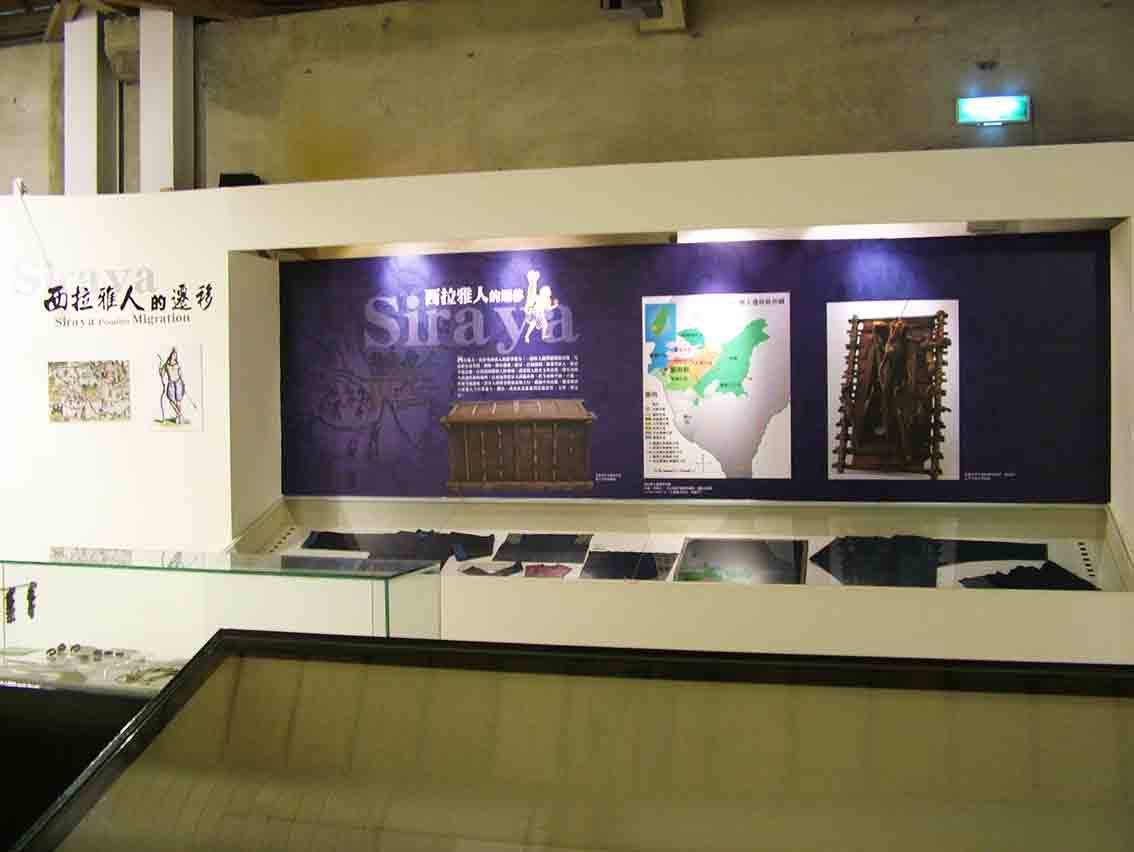 西拉雅人的遷移主題展牆，深紫色背板與木箱、地圖文物陳列