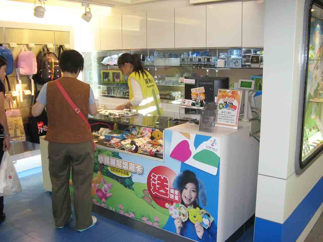 捷運商品館內部，服務人員於櫃台前為旅客介紹周邊商品