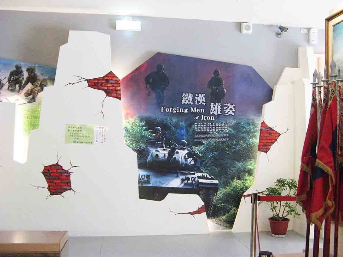 烈嶼鄉史館「鐵漢雄姿 Forging Men of Iron」展區，戰車與單兵影像融入破牆造型，紅磚破口裝飾搭配國軍旗幟