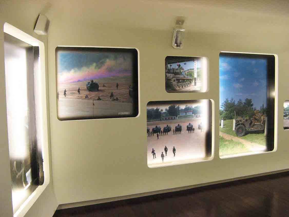 湖井頭戰史館弧形展牆，圓角窗格嵌入登陸艇衝灘、戰車整列、部隊集結與裝甲車叢林行軍等彩色軍事實景照